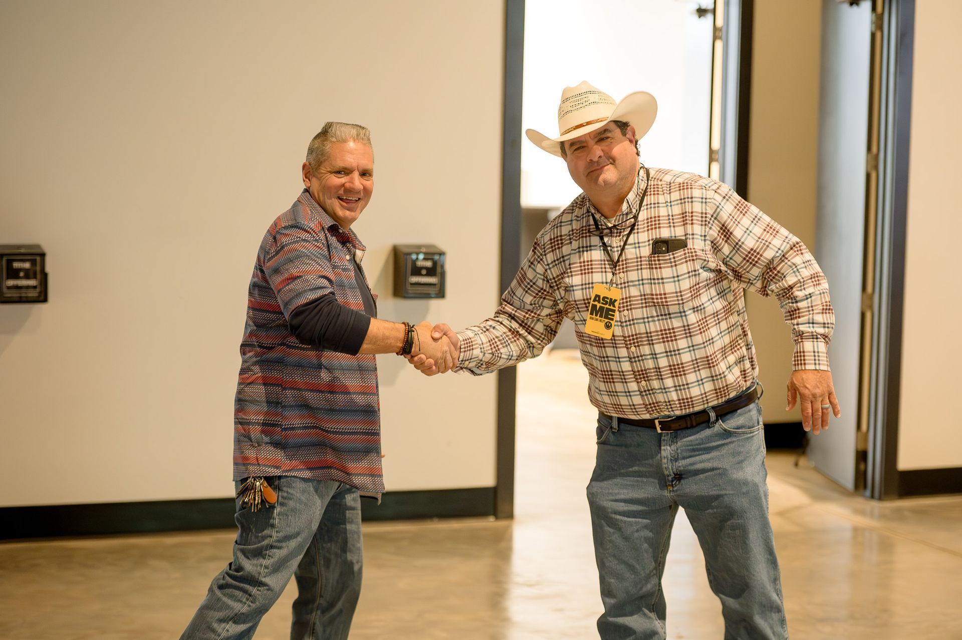 Two men in the foyer, shaking hands.