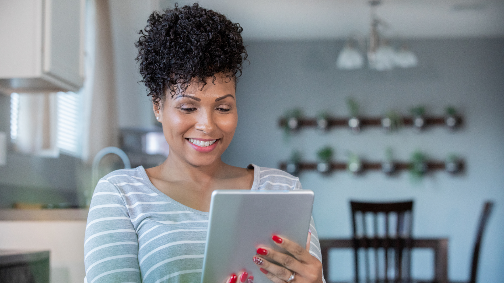 A woman is using a tablet computer in a kitchen.