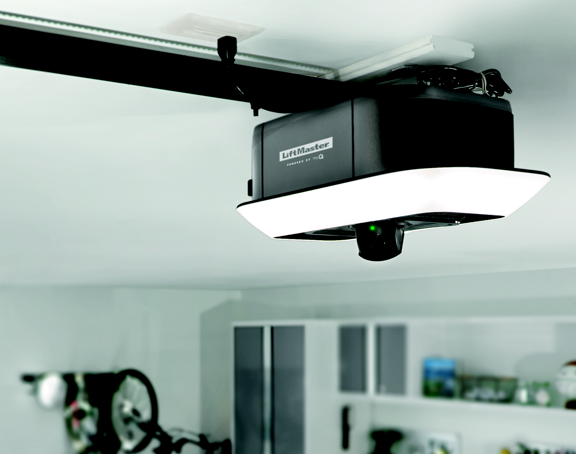 A Chamberlain garage door opener mounted to a ceiling with integrated LED lighting and a camera facing downward.