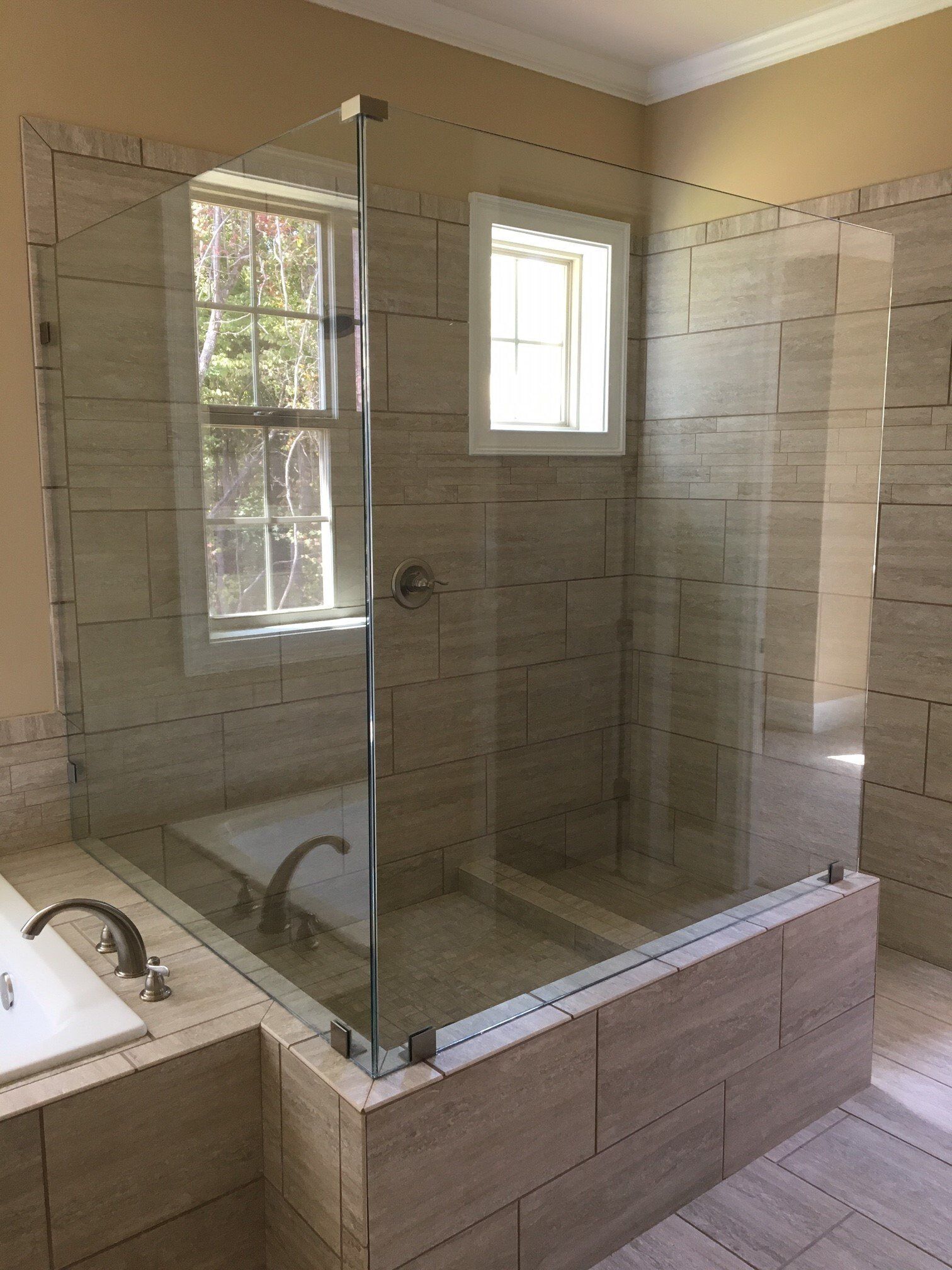 Bathroom with a glass shower enclosure and tiled walls.