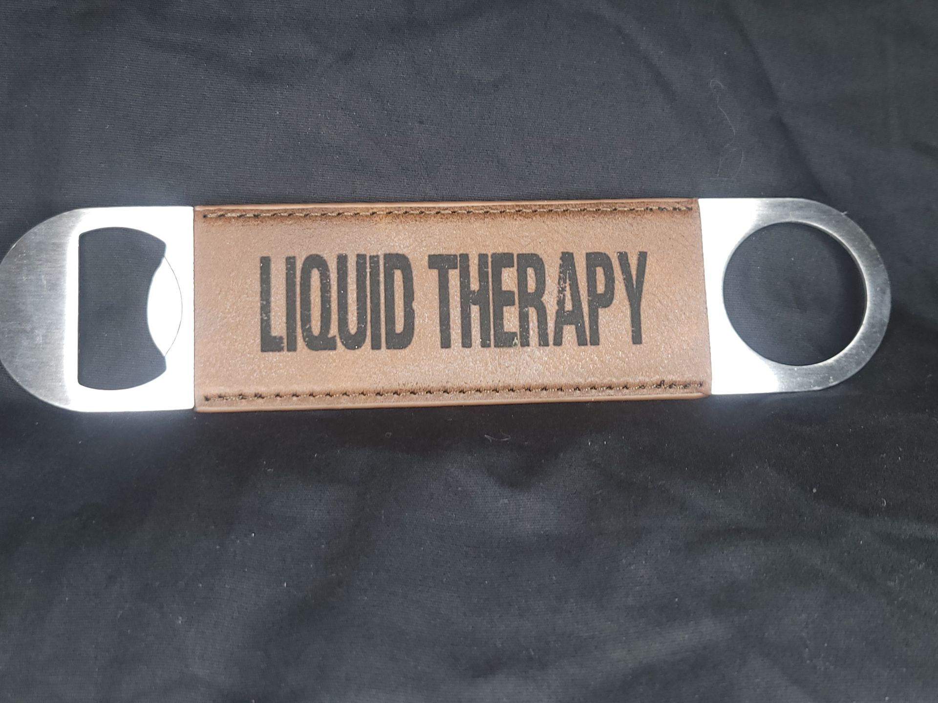 A bottle opener that says liquid therapy on it