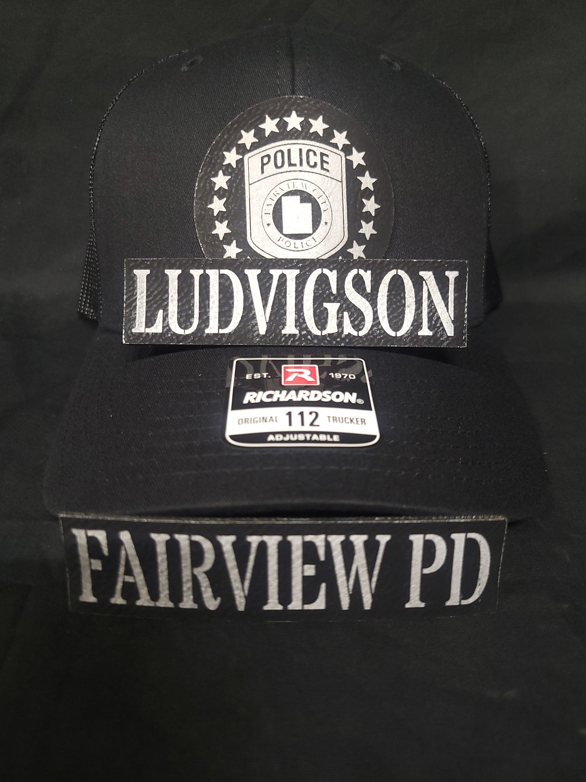 A black hat with ludvigson and fairview pd on it