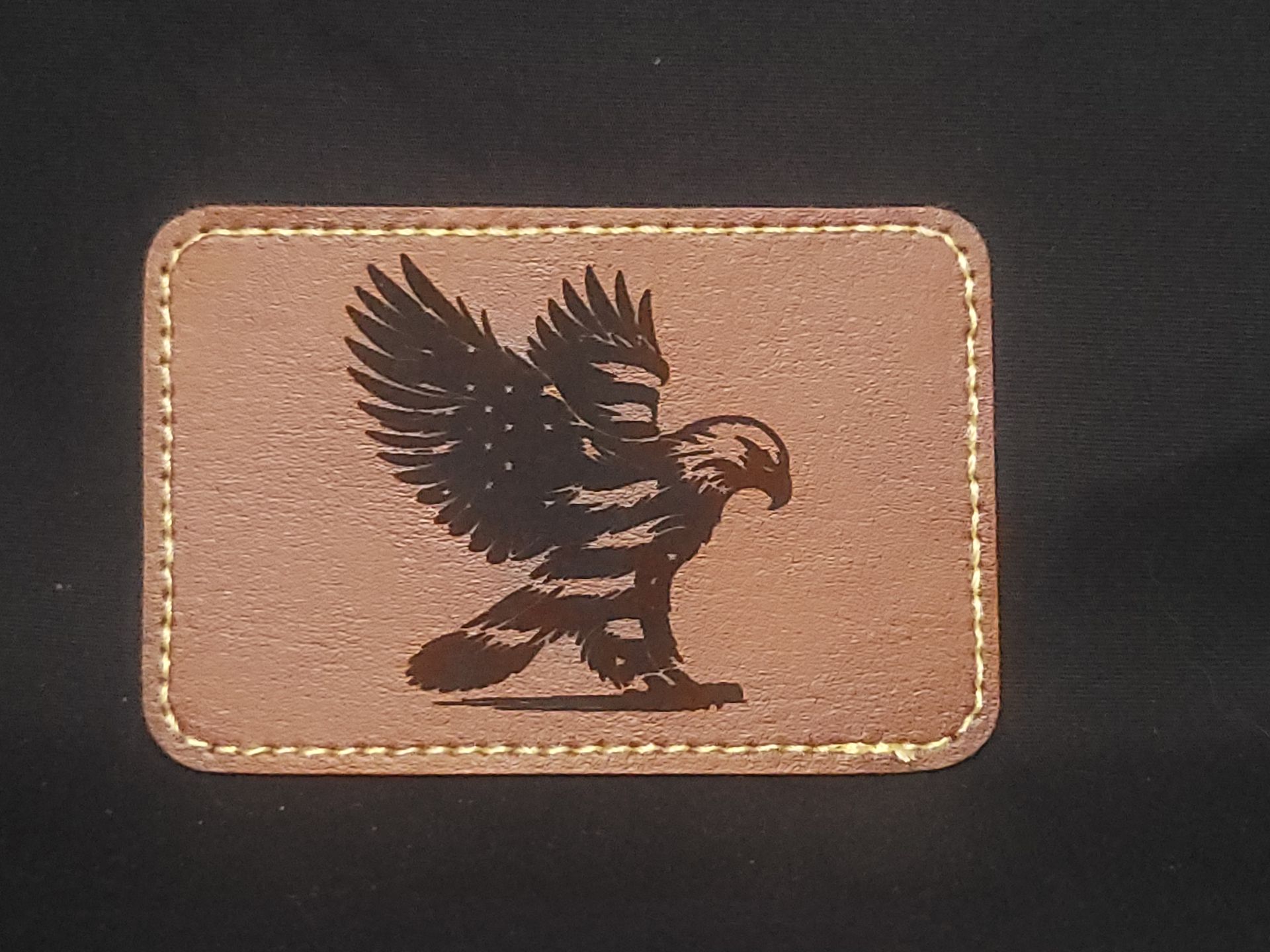A brown leather patch with an eagle on it
