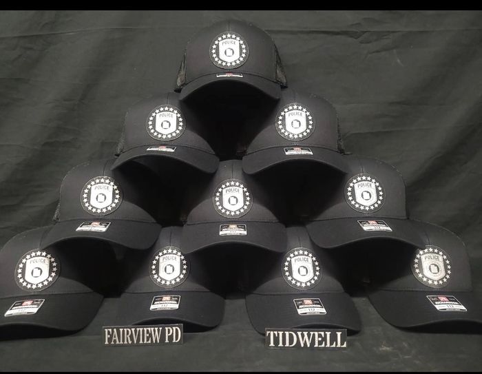 A pyramid of black hats with the letter b on them