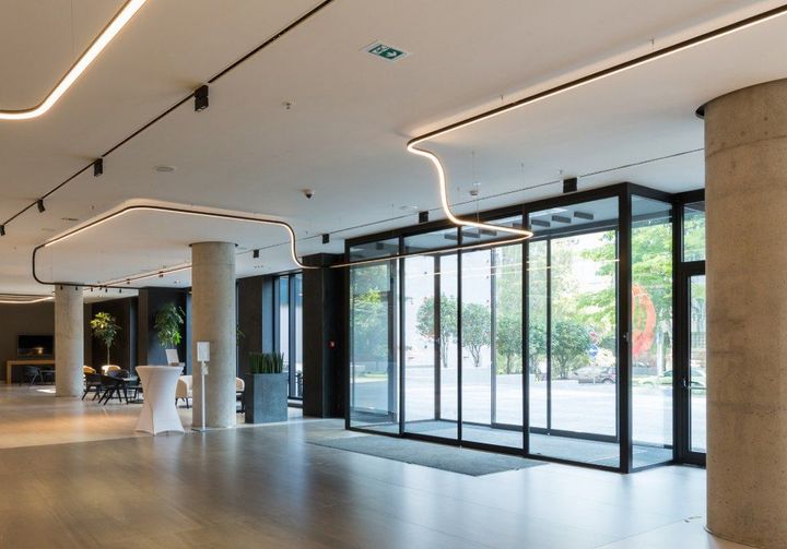 A large lobby with a sliding glass door and columns.