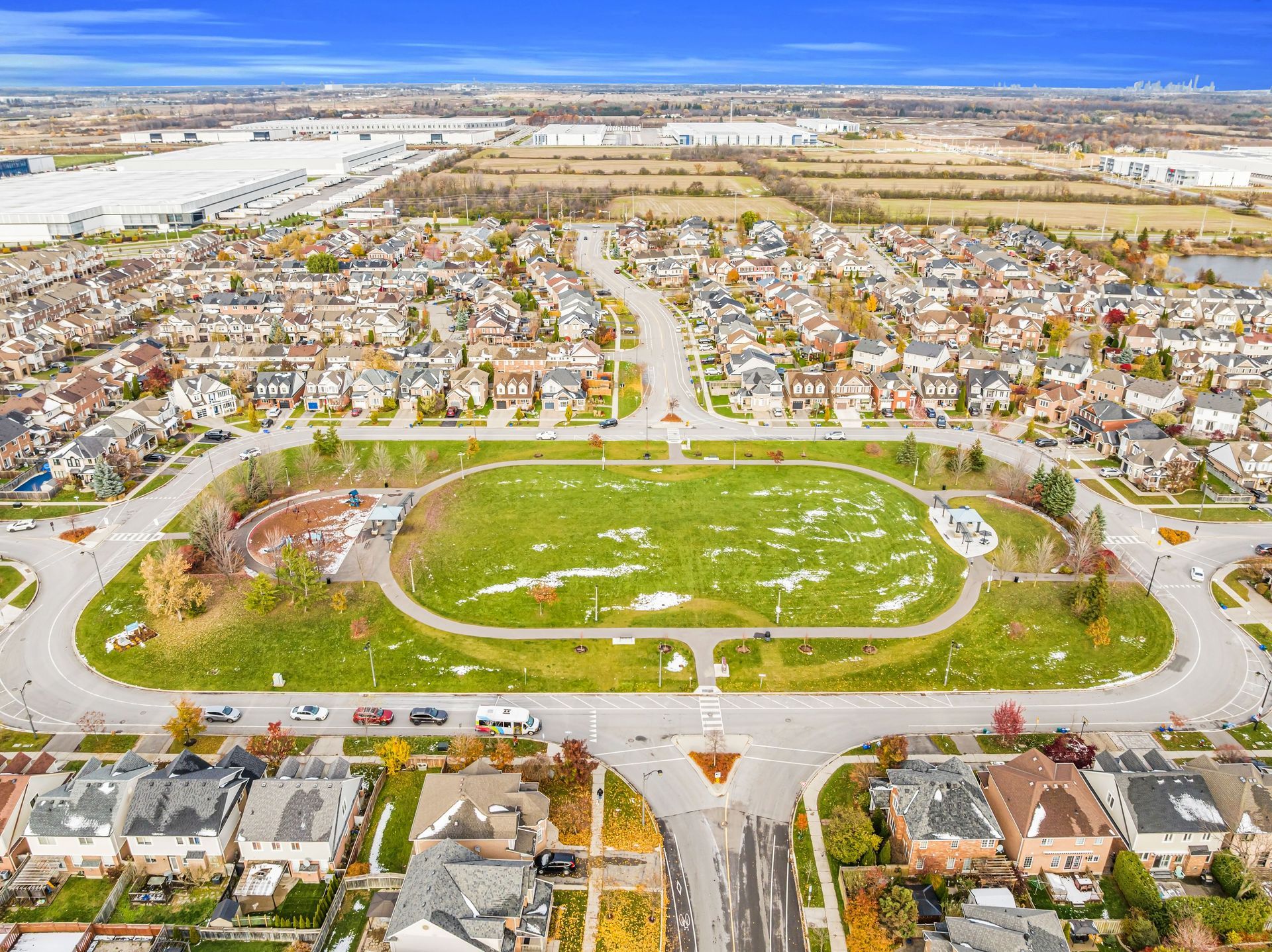 Aerial view of a suburban neighborhood with a large green park and surrounding houses.