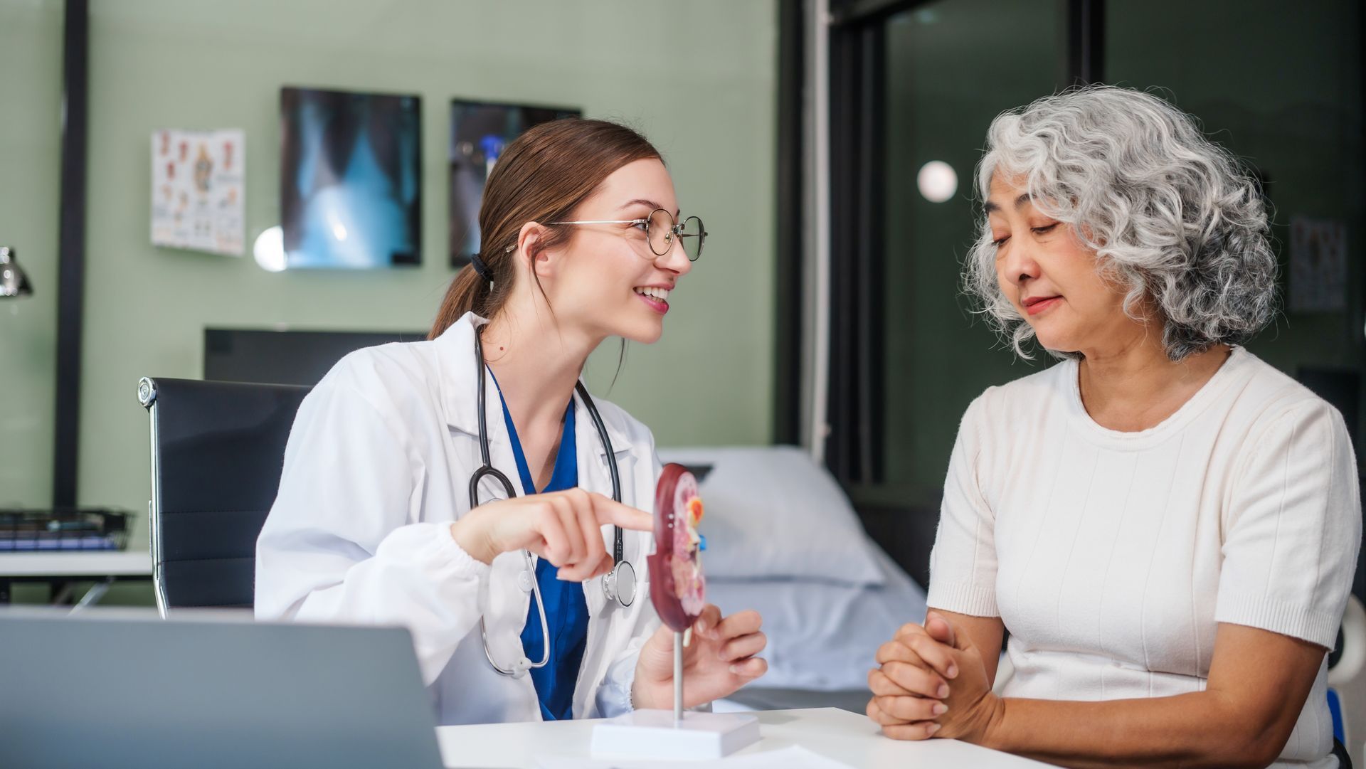 Doctor explaining a pill bottle to a patient in a clinic room