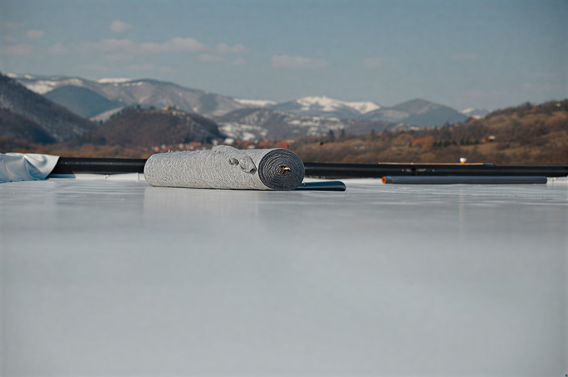 Stone sculpture on a frozen lake with snowy mountains in the background