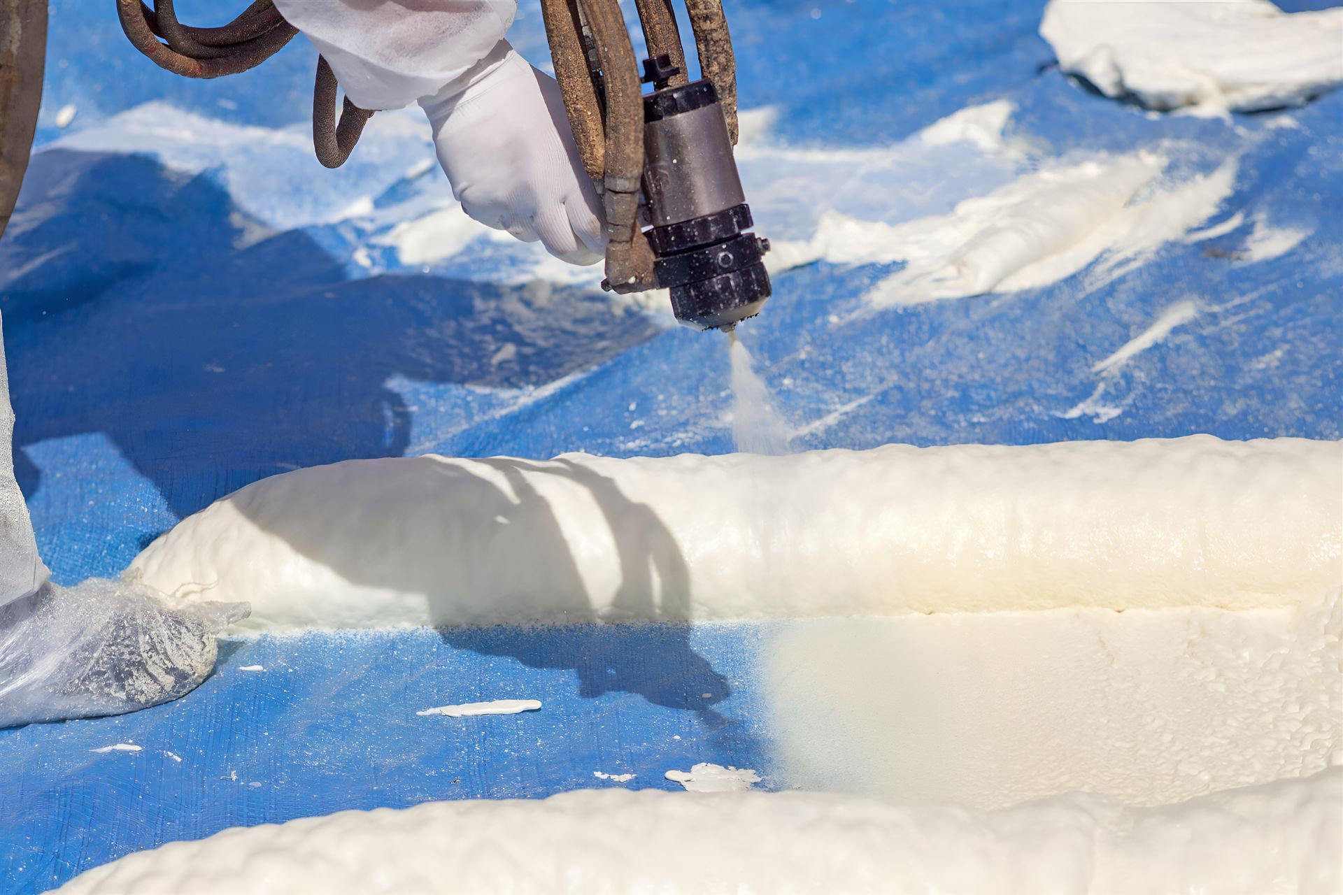 A snowboarder’s legs hover over a blue-and-white snowy slope with a shadow below.