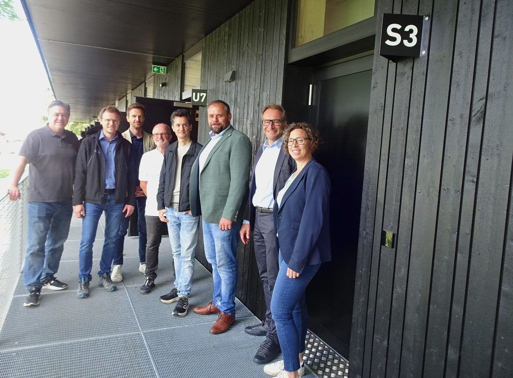 Eine Gruppe von Menschen steht vor einem Gebäude.