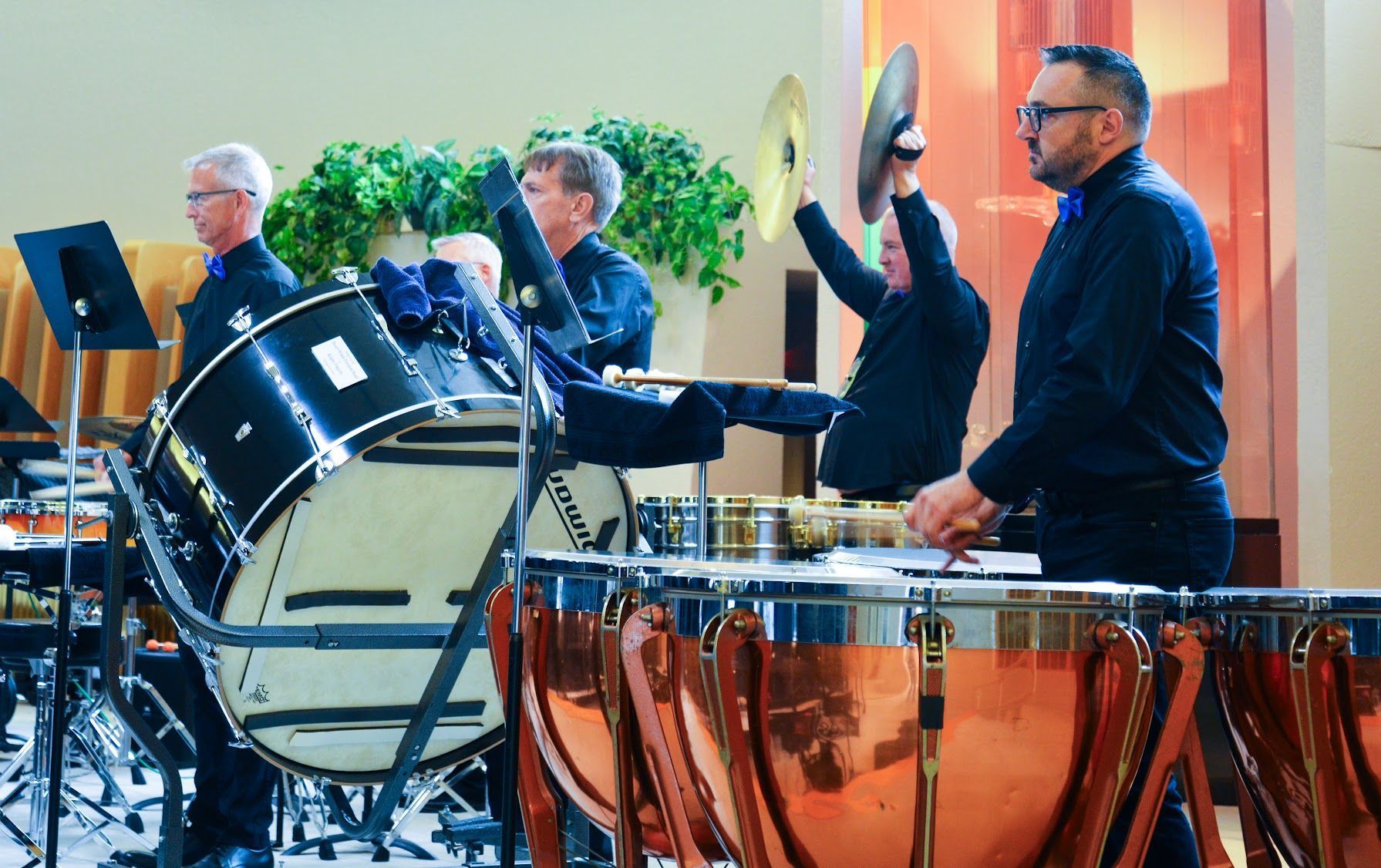 Photo from a band concert showing a tymanist, bass drum and a crashing cymbal.