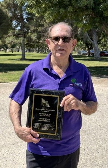 Artistic Director Dean McDowell holds an award in gratitude for the band's performance every 5 years for the last 25 years at a Memorial service near the California LGBTQ veterans memorial.