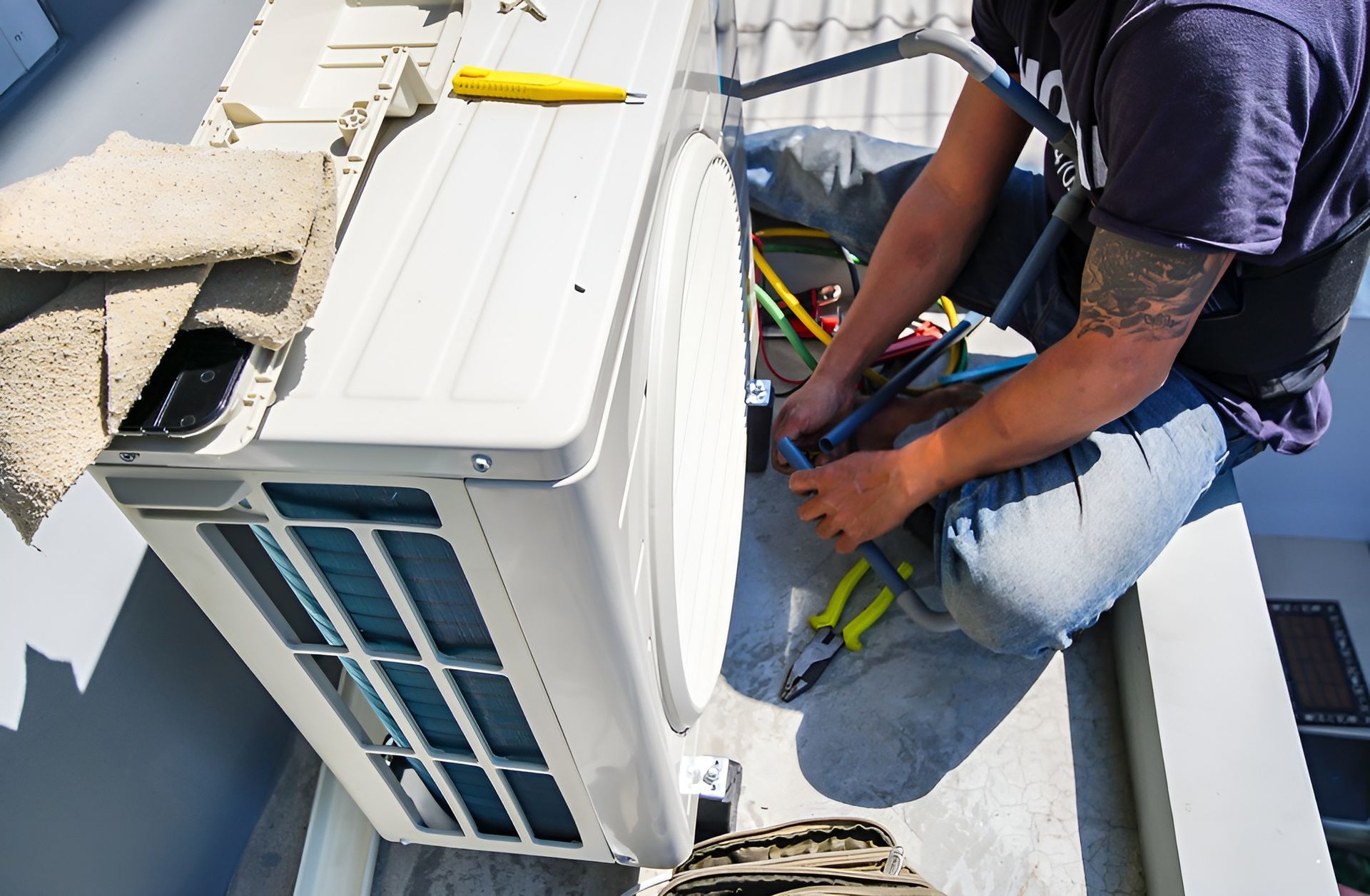 A Technician Services an Outdoor Air Conditioning Unit on A Rooftop — JF Air Conditioning Pty Ltd in Lake Macquarie, NSW