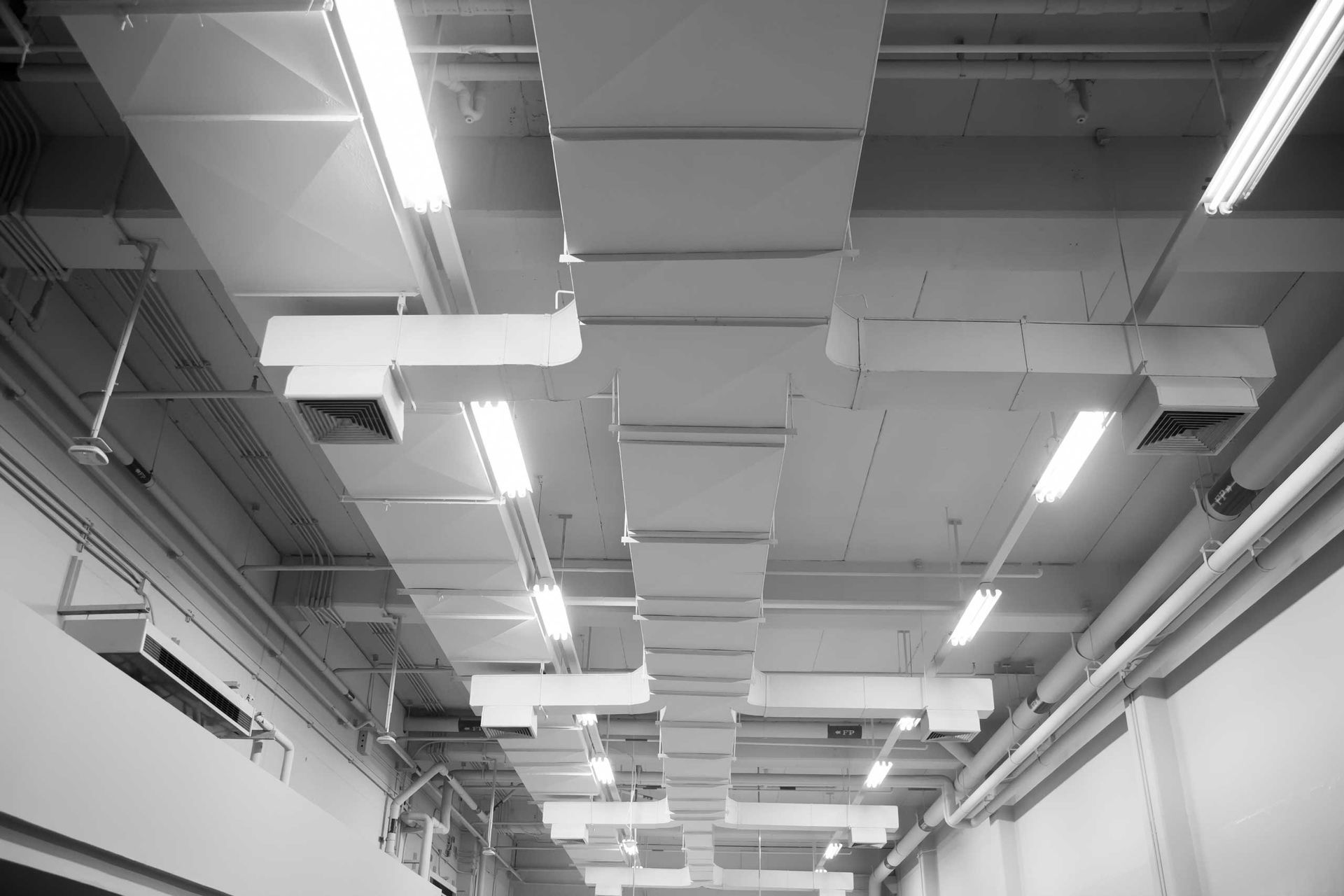 Exposed ventilation ductwork and suspended fluorescent lighting fixtures — JF Air Conditioning Pty Ltd in Lake Macquarie, NSW