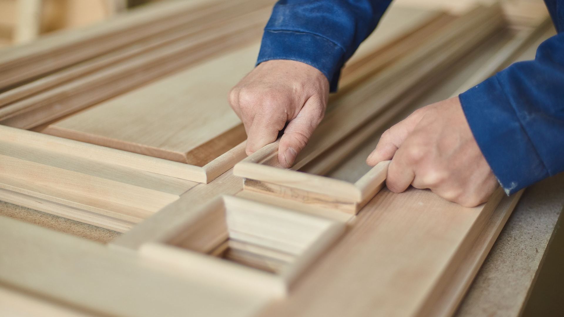A person is working on a piece of wood in a workshop.
