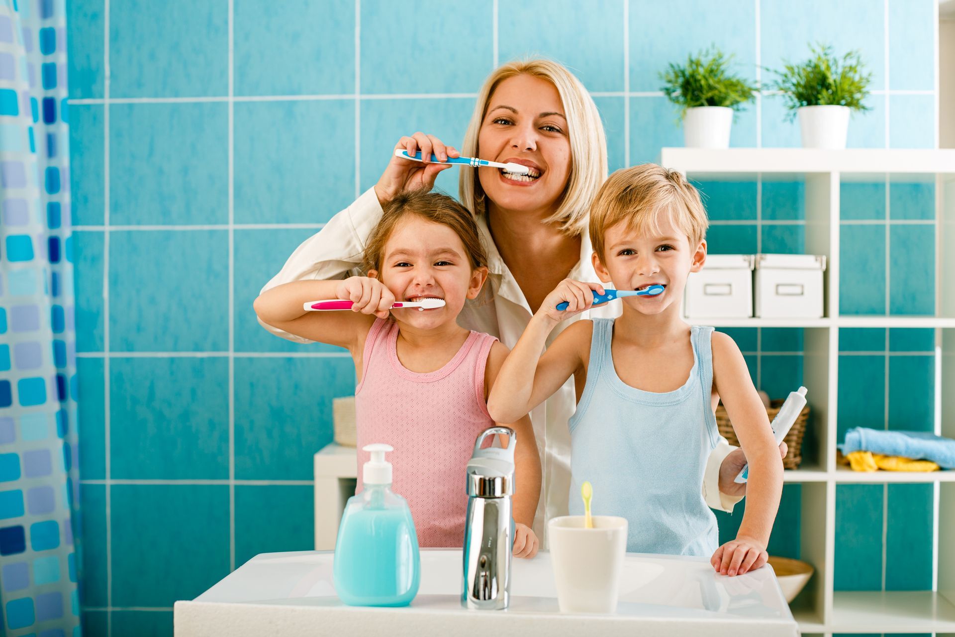 Family brushing teeth together in the bathroom - Mother brushing her teeth together with her children in the bathroom