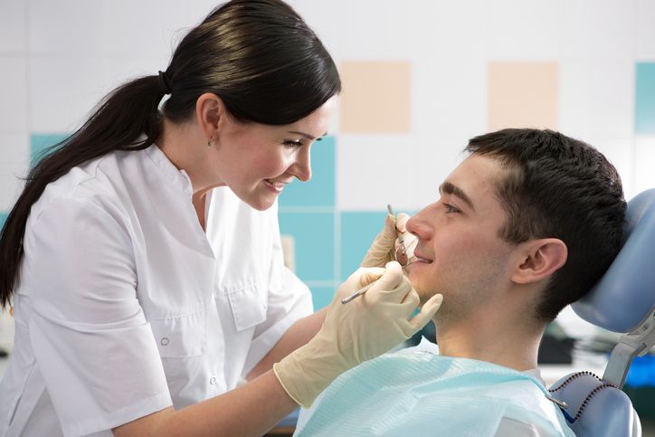 Dental professional performing routine oral exam for patient in modern clinic setting care centerbay.