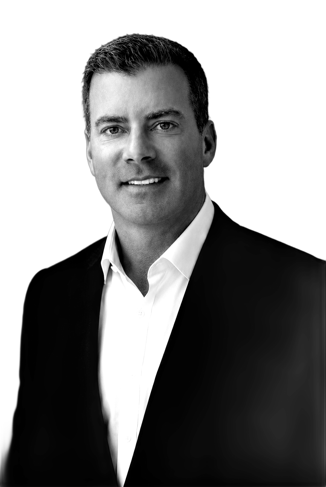 A man in a suit and white shirt is smiling in a black and white photo.