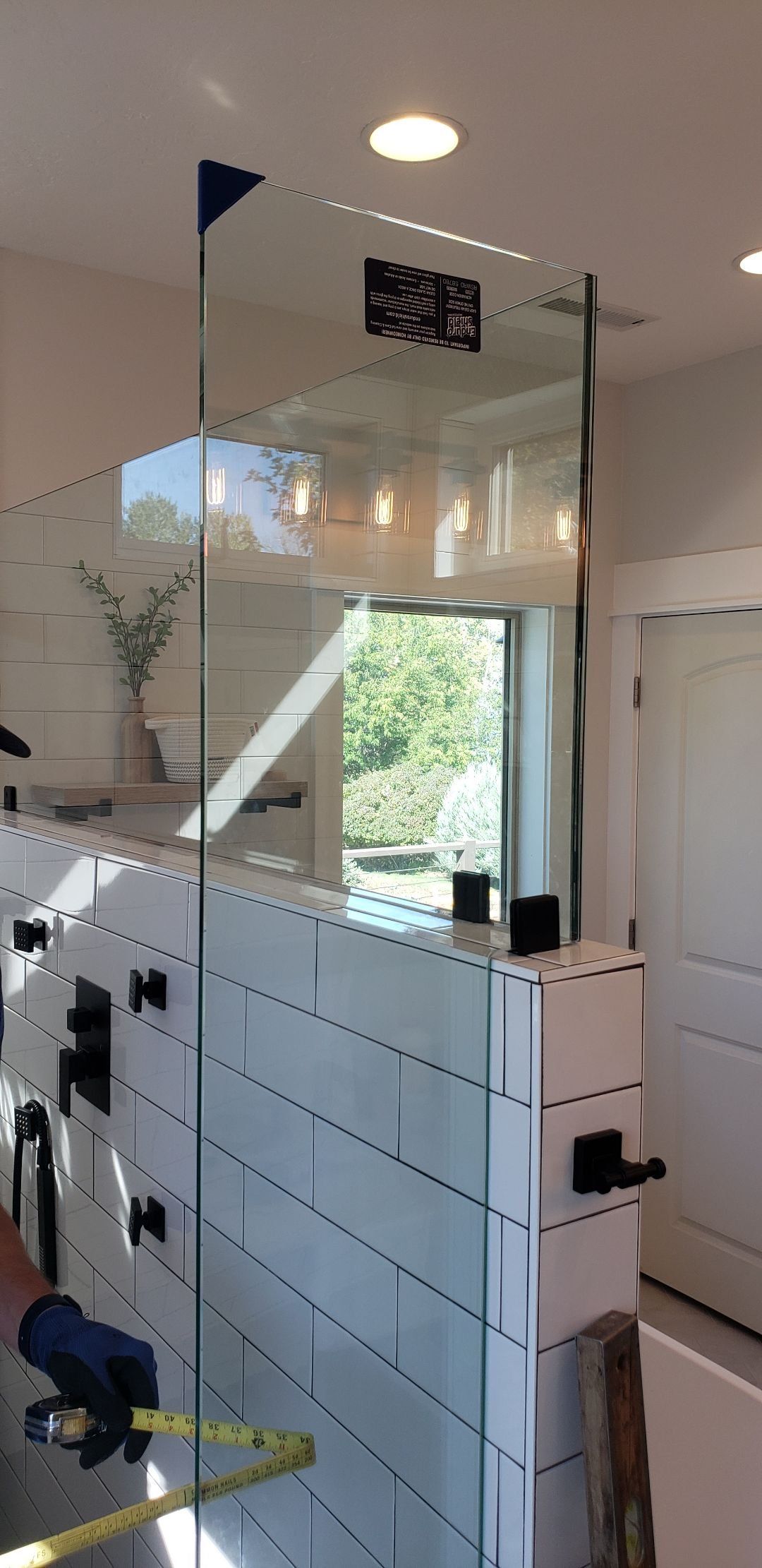 A bathroom mirror is being installed in a bathroom.