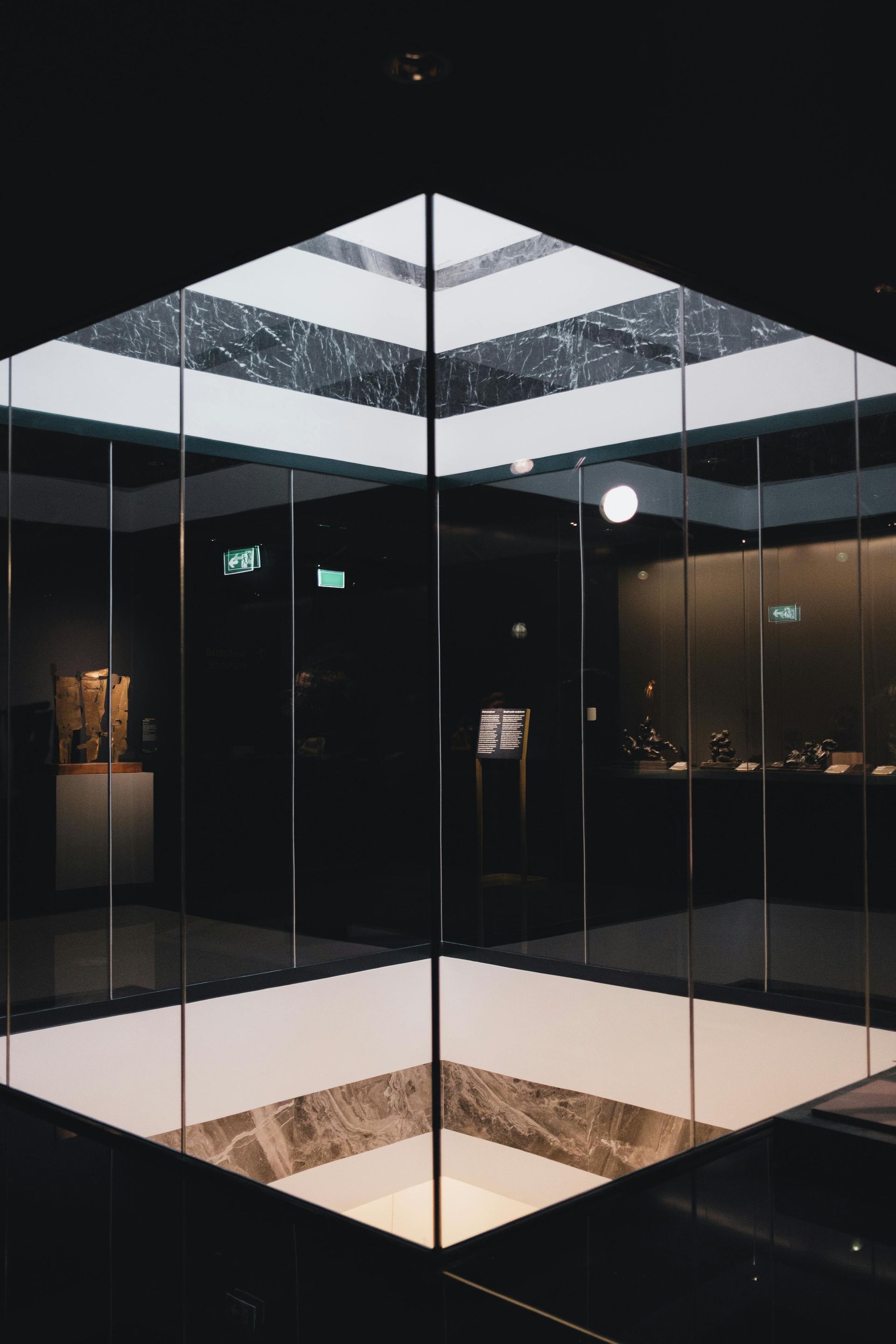 A dark room with a glass cube in the middle of it.