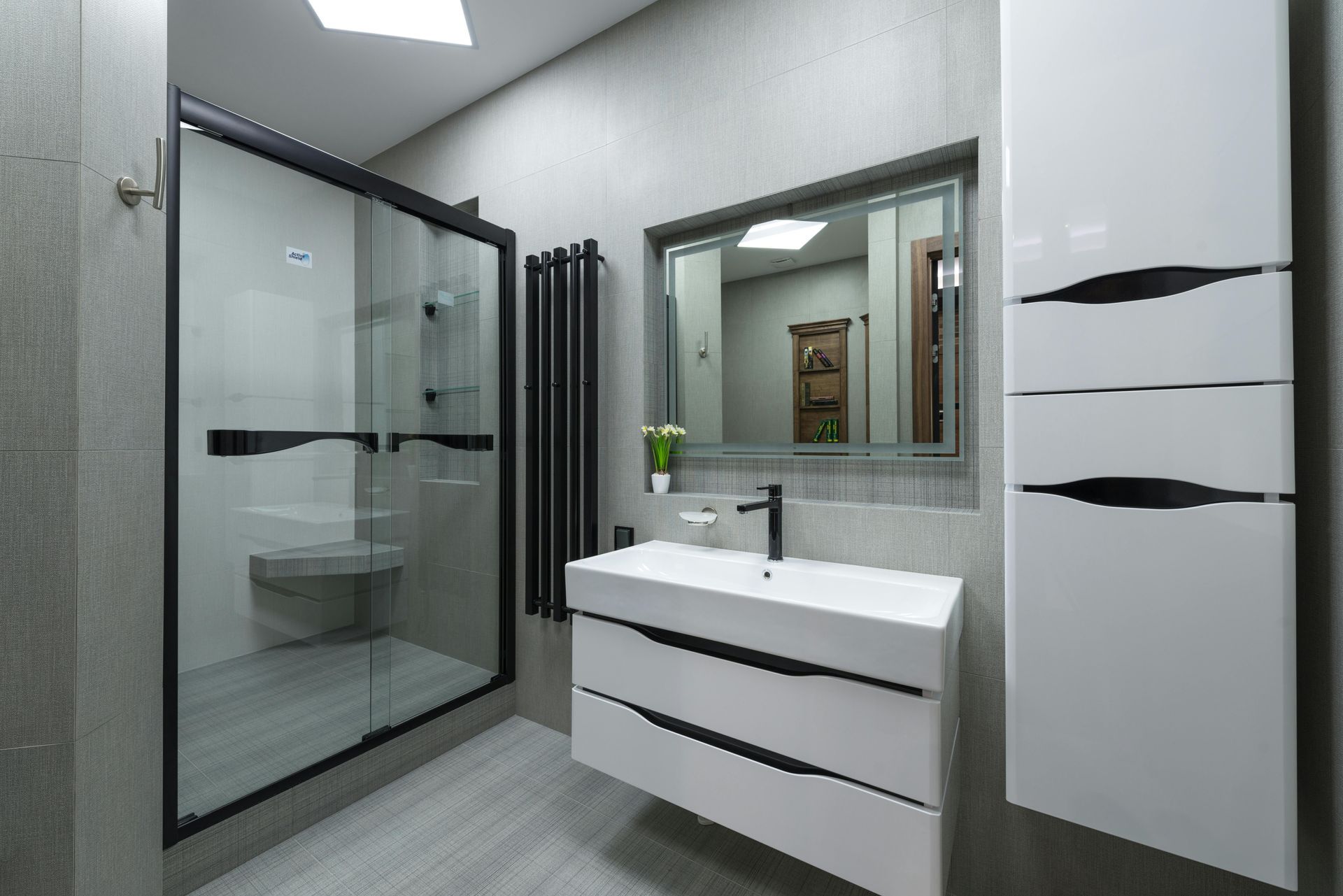 A bathroom with a sink , mirror , toilet and shower.