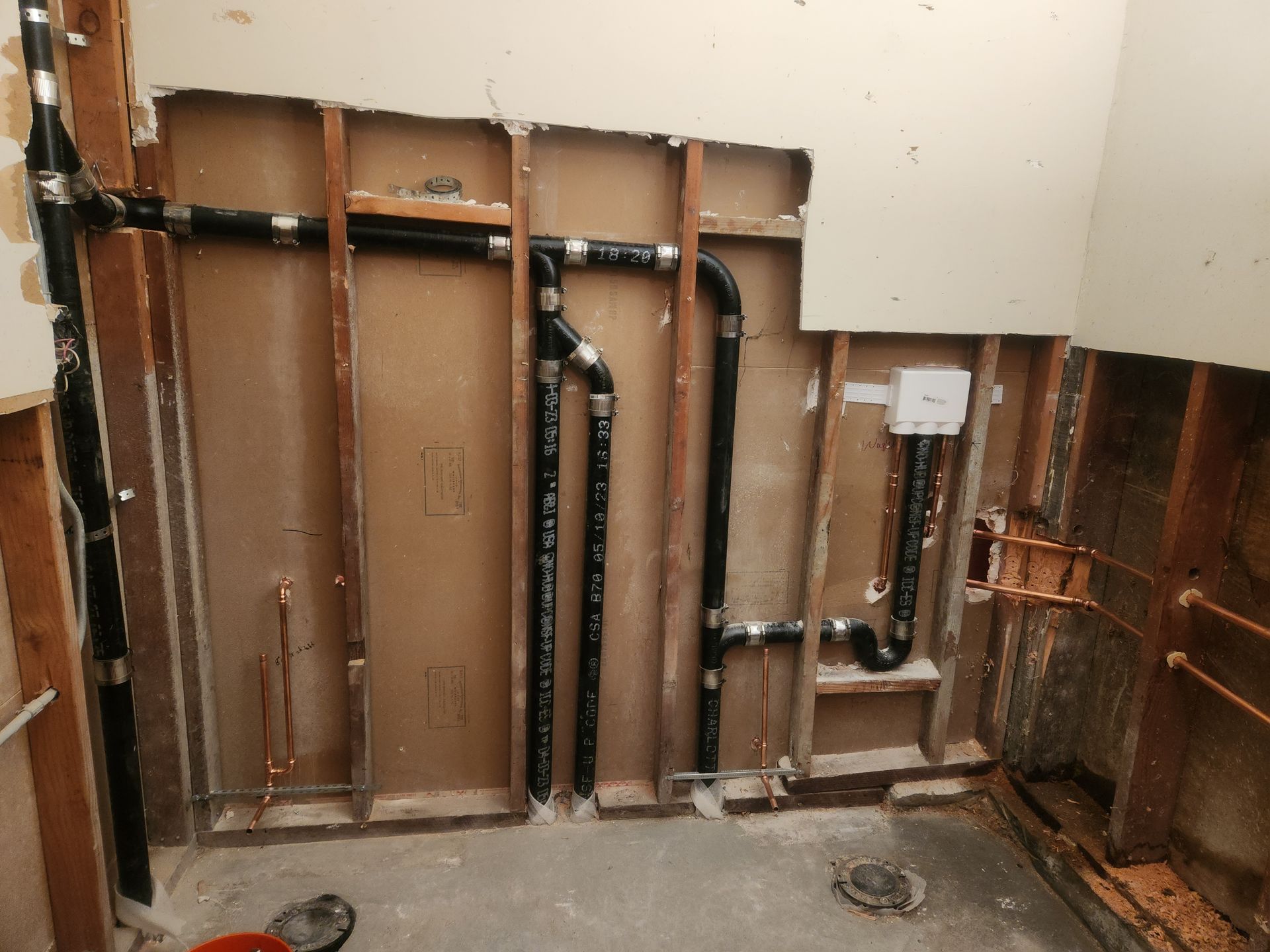 Interior wall stripped to studs with exposed plumbing and wiring during renovation