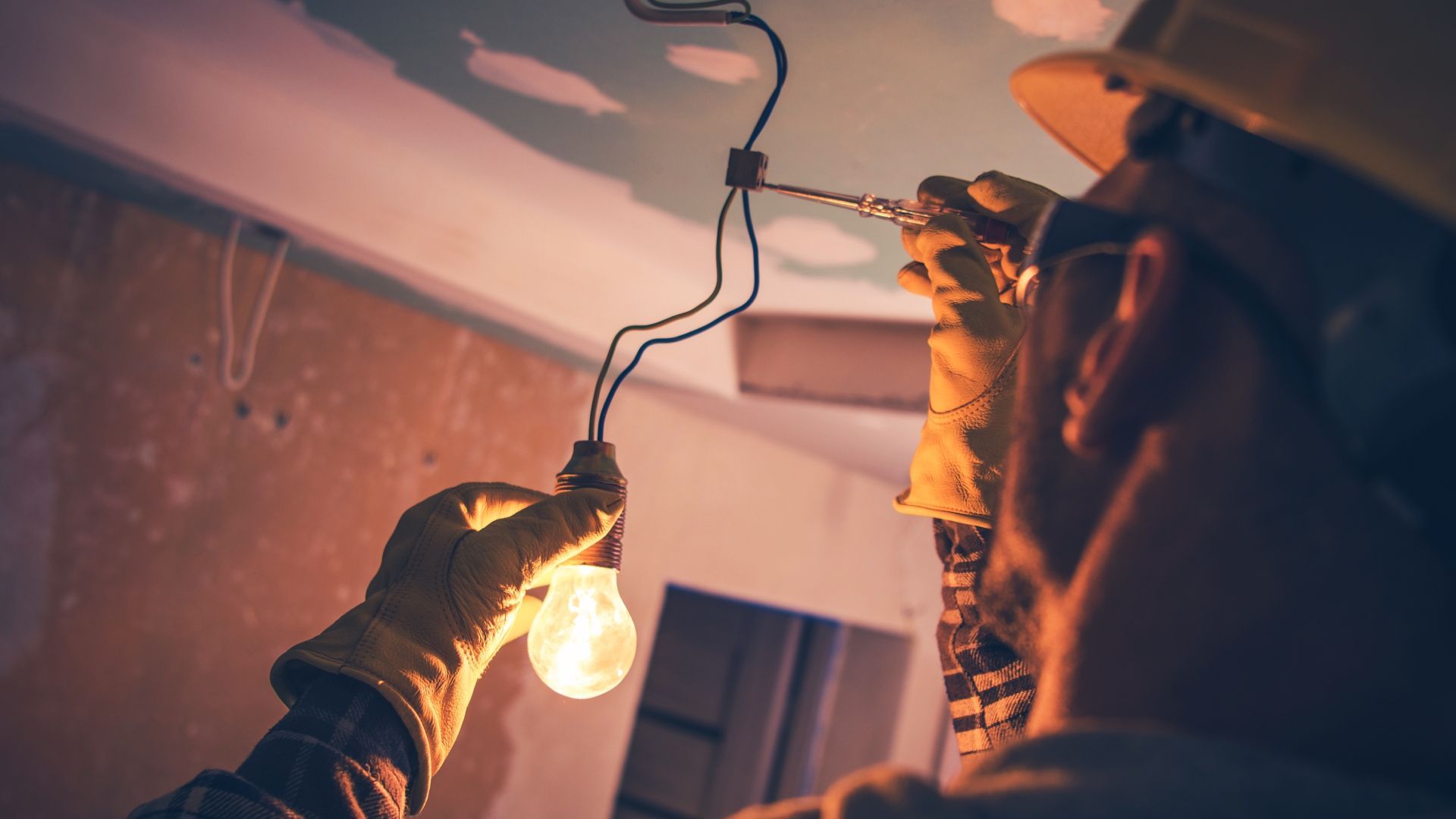 A man is holding a light bulb in his hand.