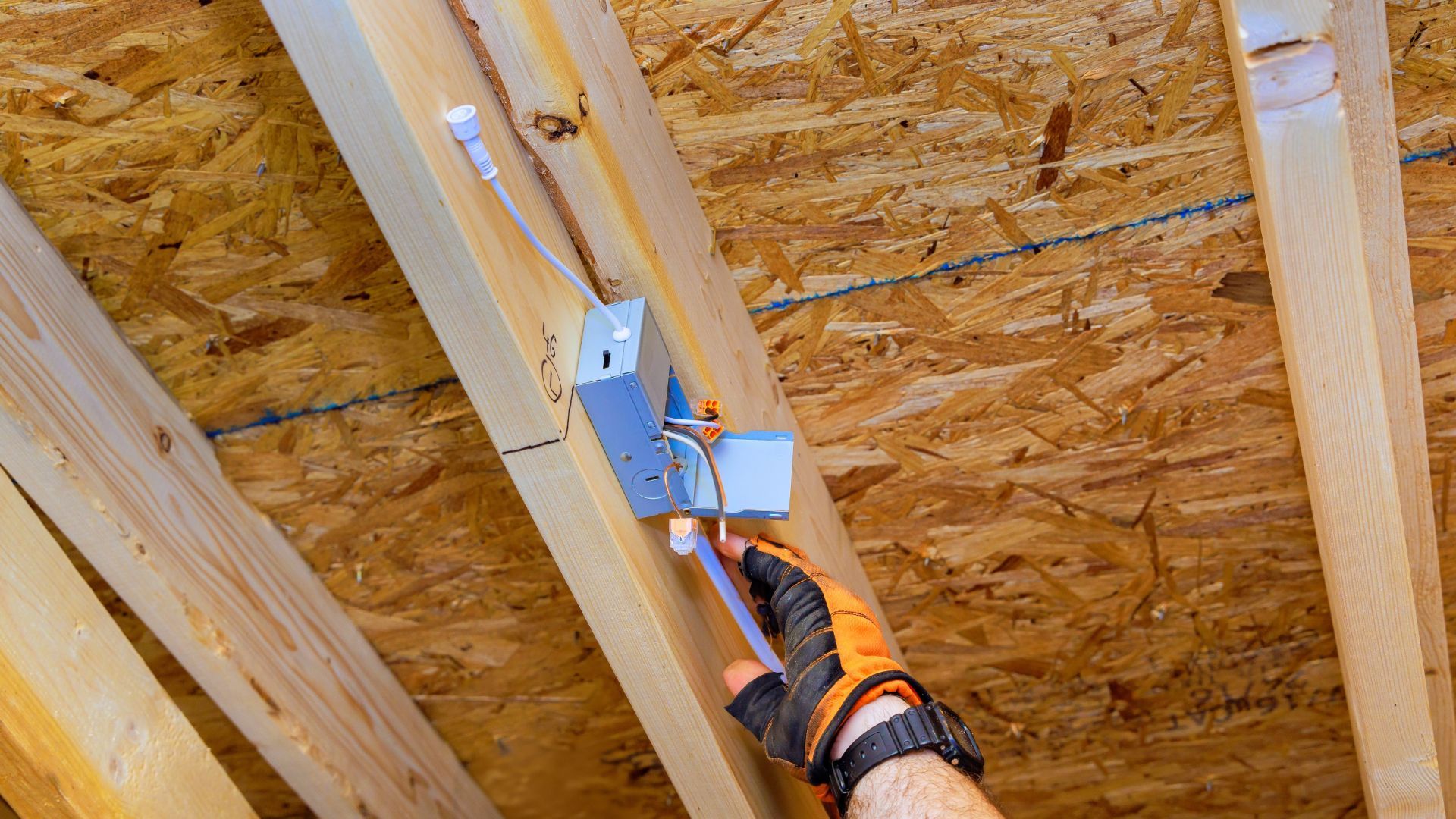A person is working on a ceiling in a house under construction.