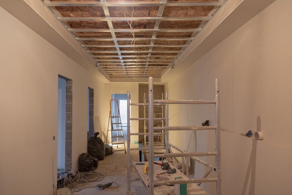 A Hallway Under Construction With Scaffolding and a Ladder — Mark's Flooring & Handyman Services in Wyong, NSW
