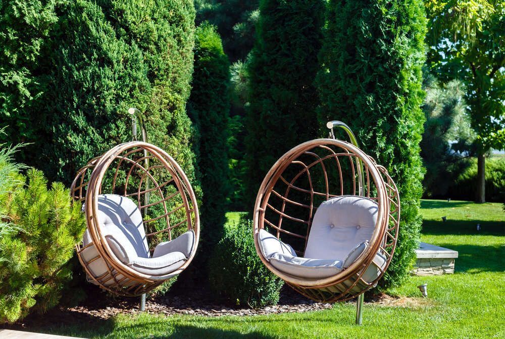 Two Hanging Chairs in a Garden With Trees in the Background — Mark's Flooring & Handyman Services in Wyong, NSW