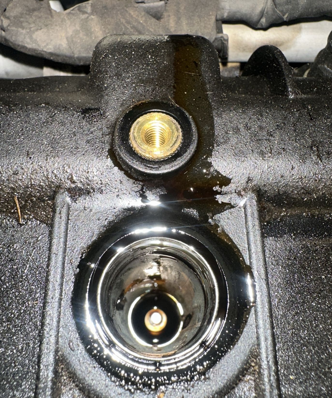 Engine oil pooled inside a Jeep spark plug well