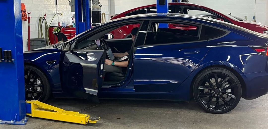Technician servicing Tesla Model 3 passenger seat