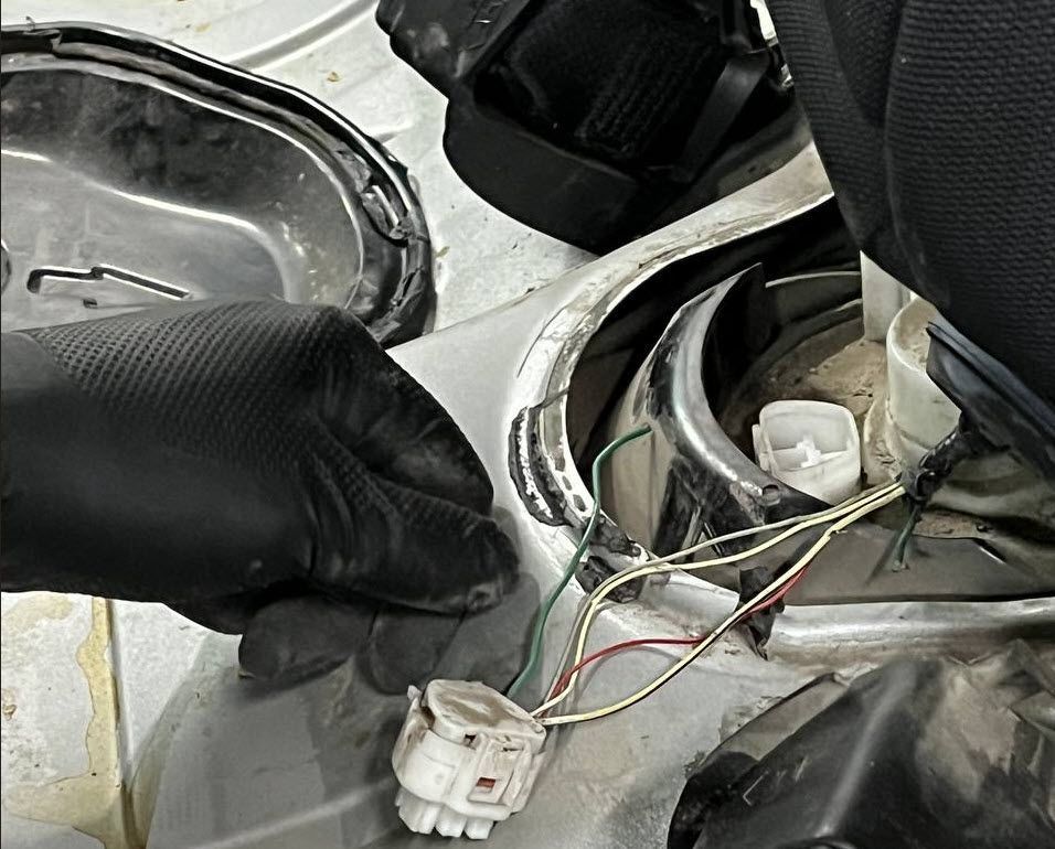 Damaged fuel pump wiring under Corolla rear seat