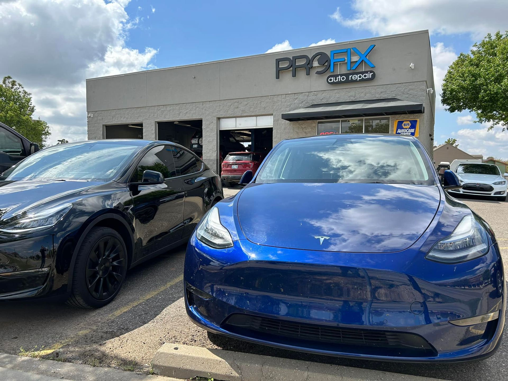 Blue Tesla In front of Auto Shop | PROFIX Auto Repair and Leon's PROFIX Auto Repair