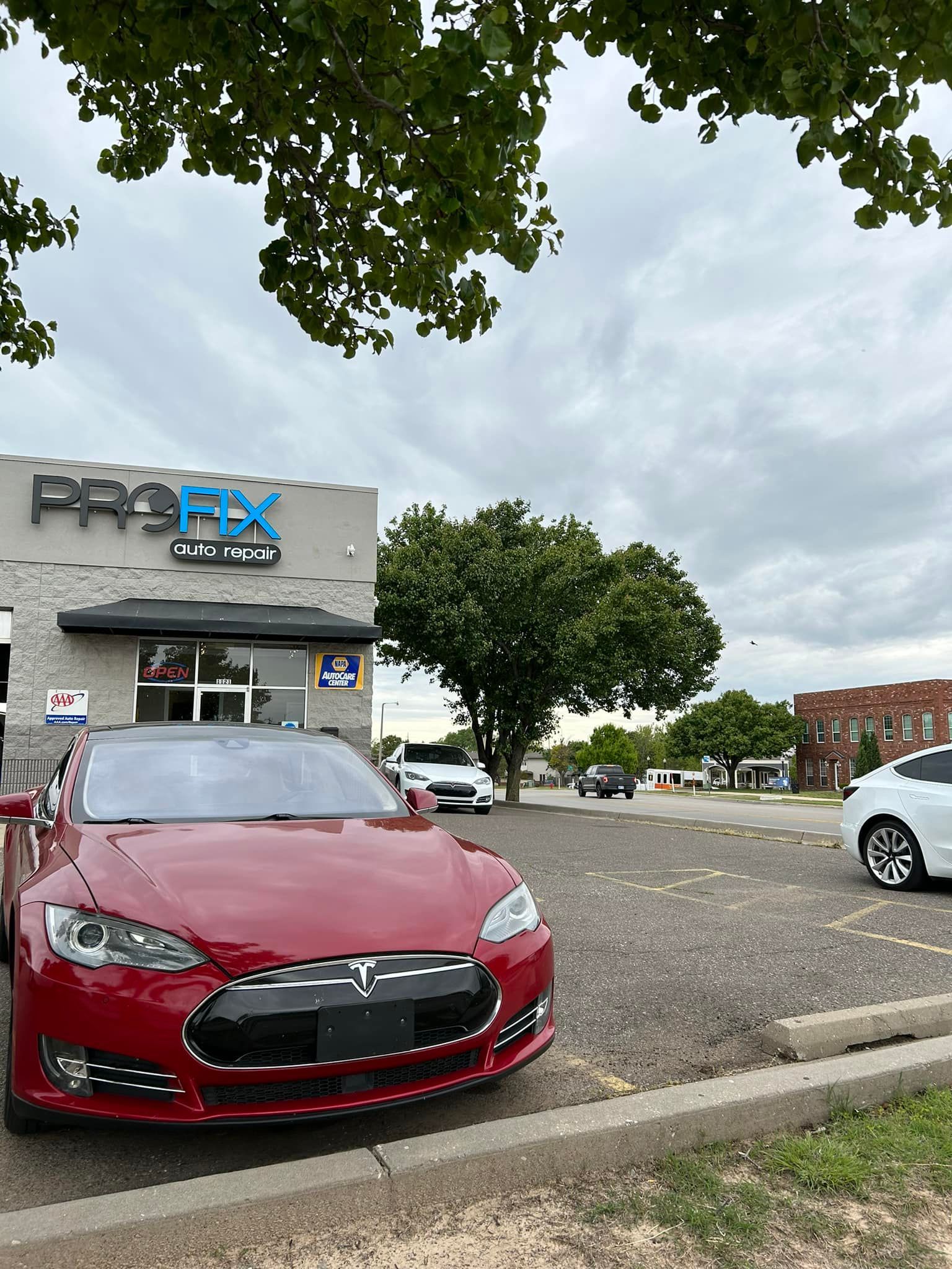 Red Tesla In front of Auto Shop | PROFIX Auto Repair and Leon's PROFIX Auto Repair