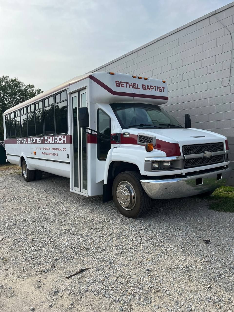 GMC C5500 commercial shuttle bus receiving air-conditioning service in Norman OK
