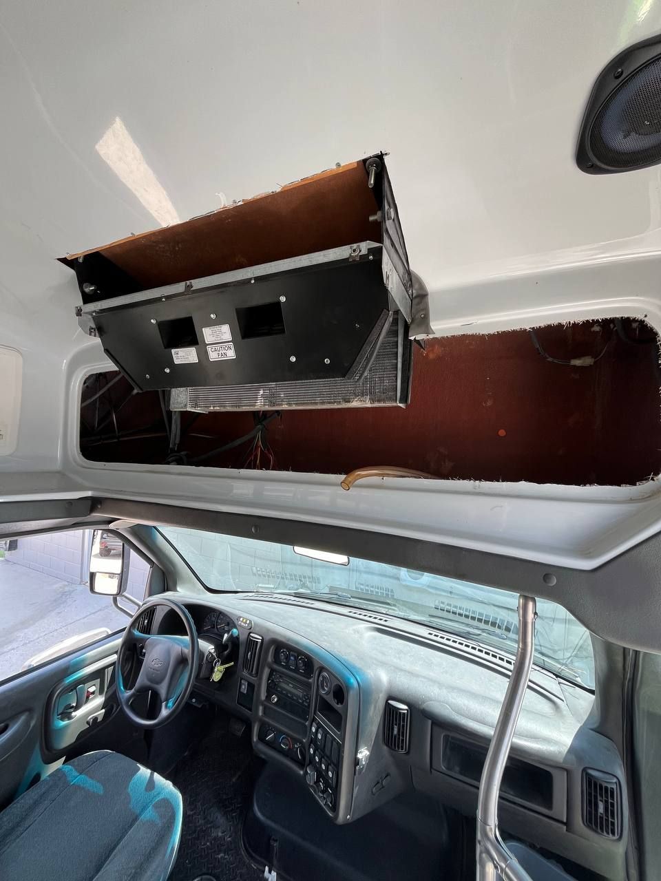 Rear air-conditioning evaporator and blower assembly inside a commercial shuttle bus