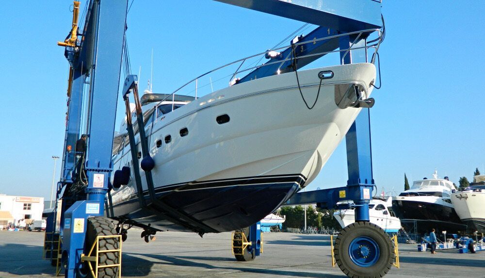 A Boat is Being Lifted by a Crane in a Marina — Activate Auto Electrics & Air Conditioning In Caloundra, QLD