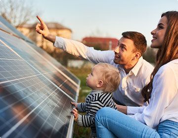 couple with child looking a solar panel
