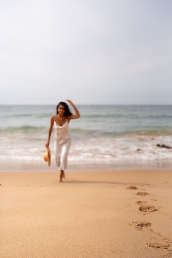 Freelance copywriter Anam Ahmed on a beach in a white dress.