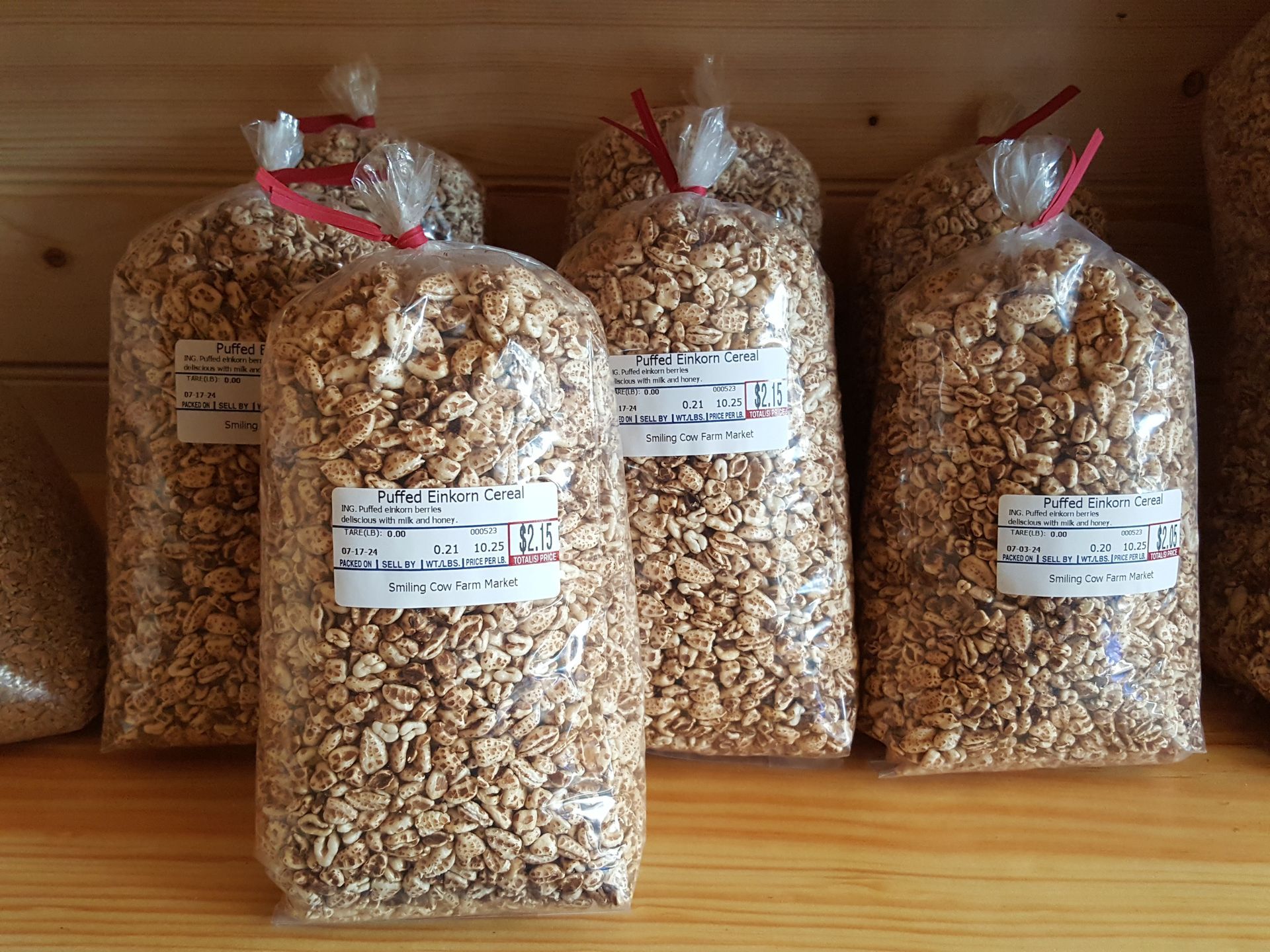 Several bags of grains are sitting on a wooden table