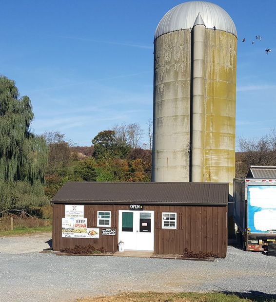 A small building with a silo in the background