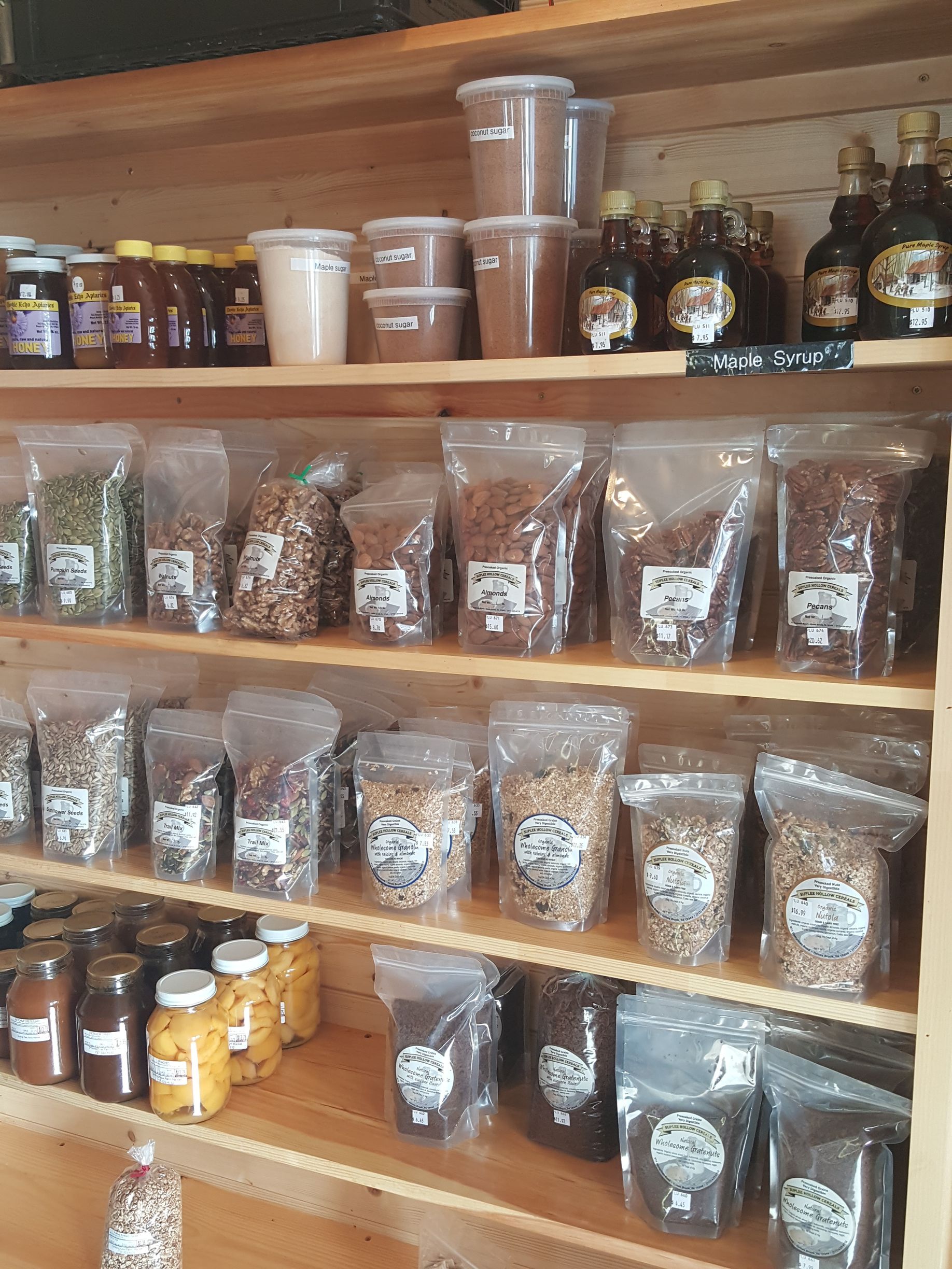 A shelf filled with bags of food and bottles of syrup.