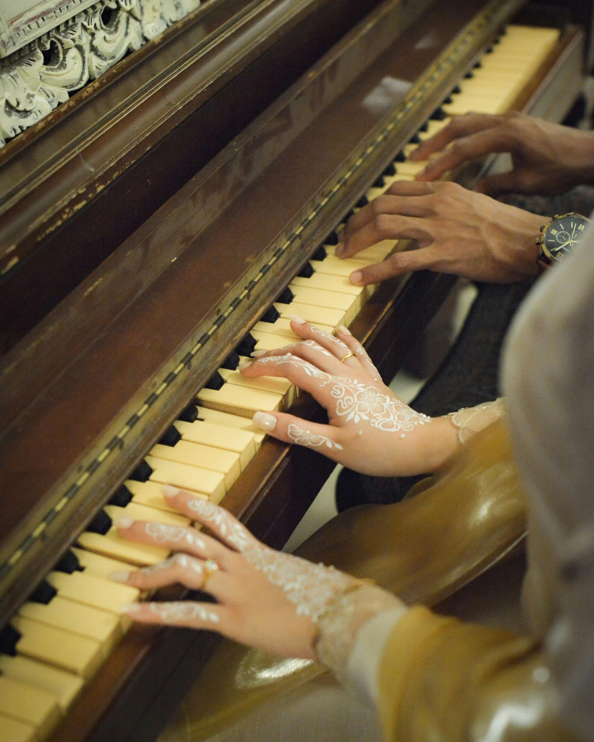 Duas pessoas tocando piano juntas