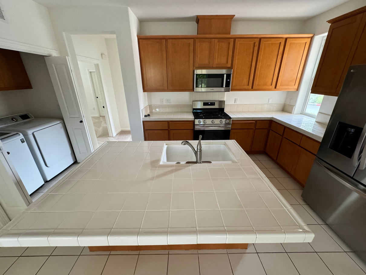 A kitchen with stainless steel appliances and wooden cabinets