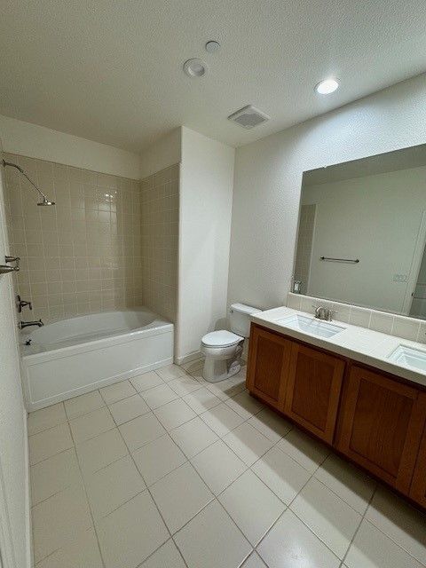 A bathroom with a tub , toilet , sink and mirror