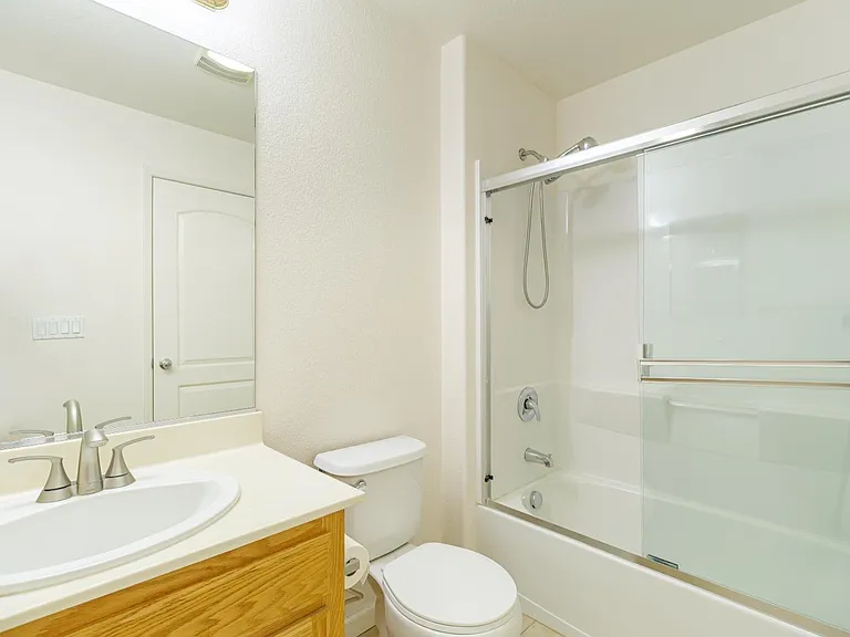 Bathroom with a white toilet, sink, bathtub, and shower.