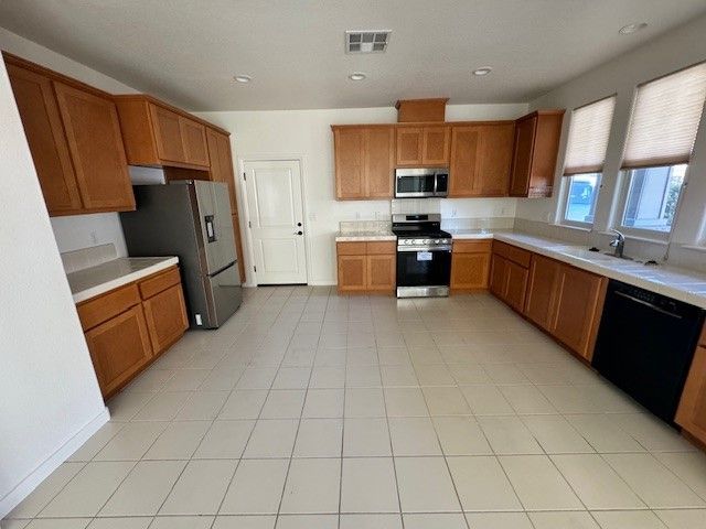 A kitchen with wooden cabinets a stove and a refrigerator