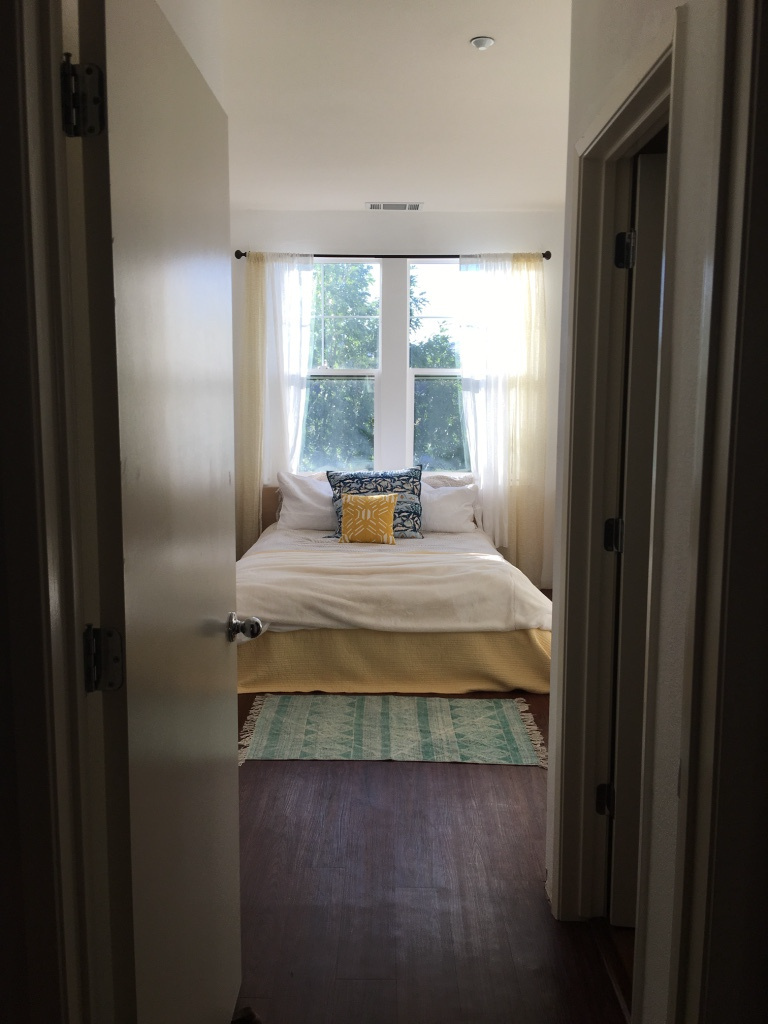 A bedroom with a bed and a window.