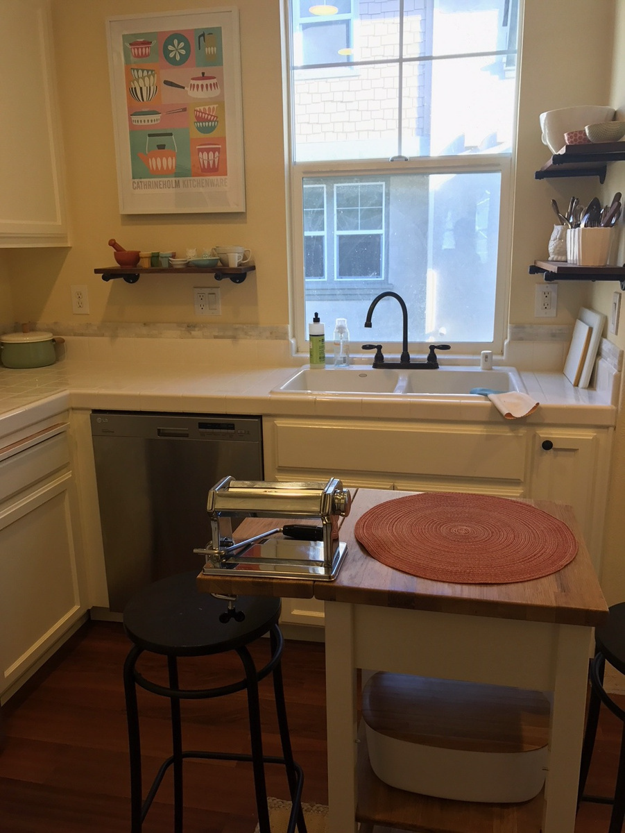 A kitchen with a sink a table and a stool